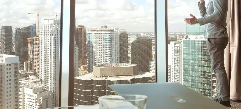 Man at high-rise window, city skyline