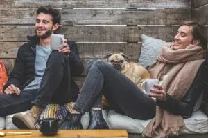 Couple relaxing on couch with pug