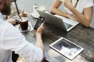 People with phone laptop at cafe