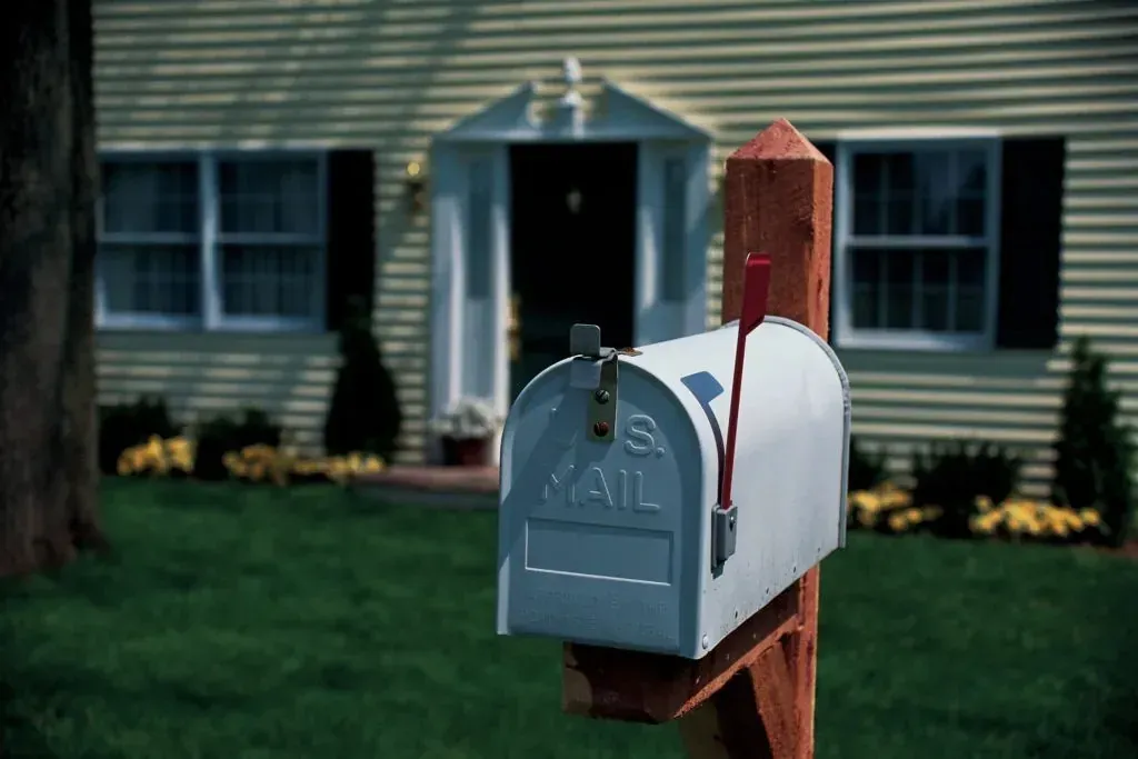 Generic U.S. Mail mailbox in front of suburban house