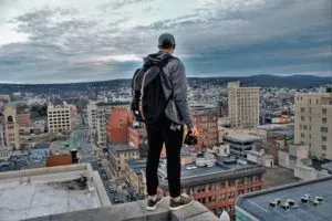 Man on rooftop overlooking city