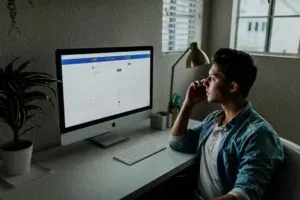 Man on phone at computer desk