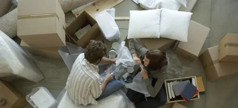 Overhead view of couple unpacking boxes and pillows