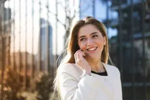 Smiling woman on phone outdoors