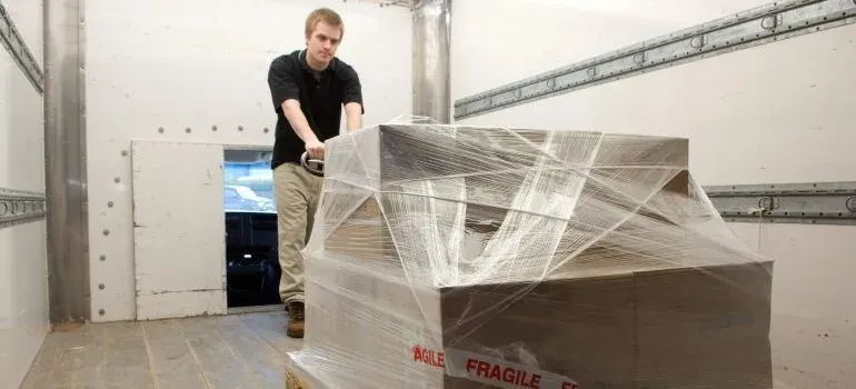 Mover with shrink-wrapped pallet in truck