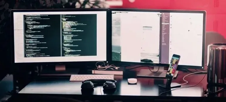 Dual-monitor desk setup showing code on screens
