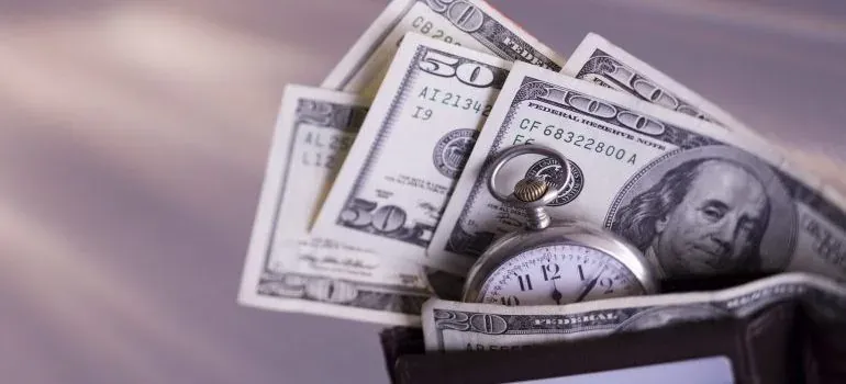 Dollar bills and pocket watch in wallet