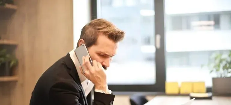 Businessman in suit making a phone call at office