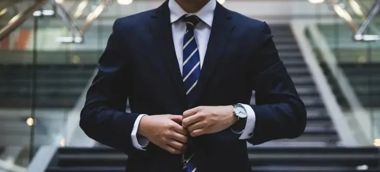 Businessman in navy suit buttoning his jacket