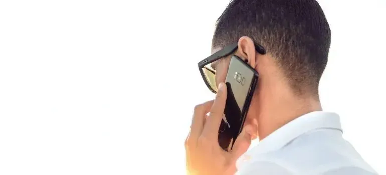 Man with sunglasses talking on phone, seen from behind