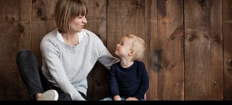 Mother and toddler against wood wall