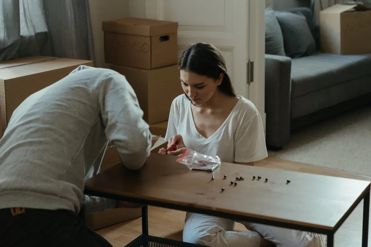 Couple assembling table among moving boxes