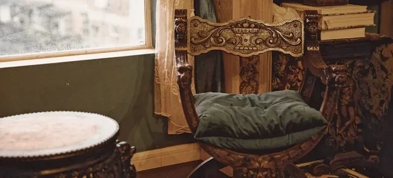Ornate antique carved chair by window