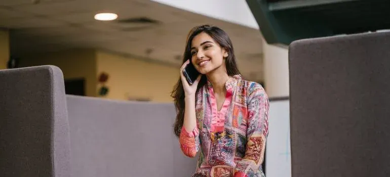 Smiling woman in floral top talking on phone