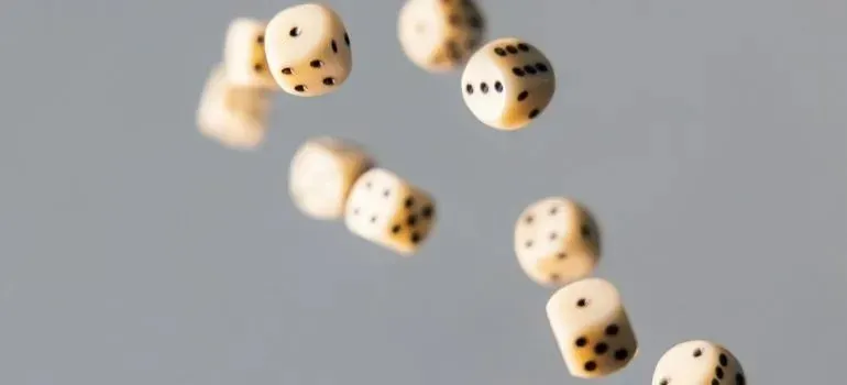 White dice tumbling mid-air against gray background