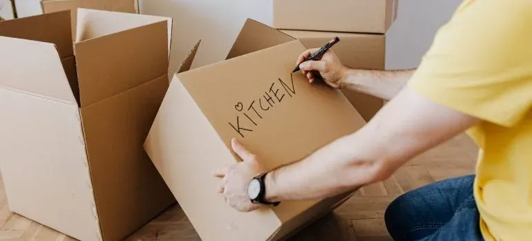 Man labeling box KITCHEN