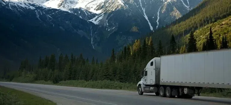 Unmarked white semi-trailer truck on mountain highway