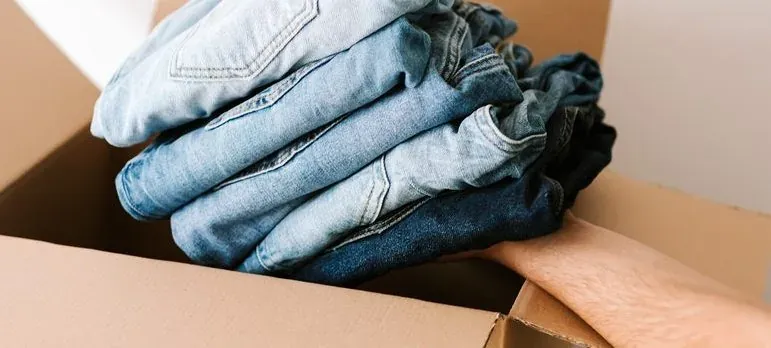 Folded jeans in cardboard box
