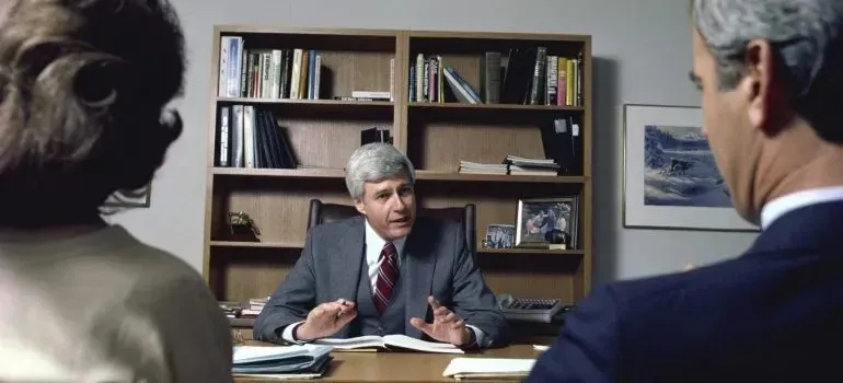 Advisor talking with couple across office desk