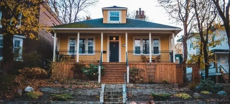 Yellow craftsman house with front porch in autumn