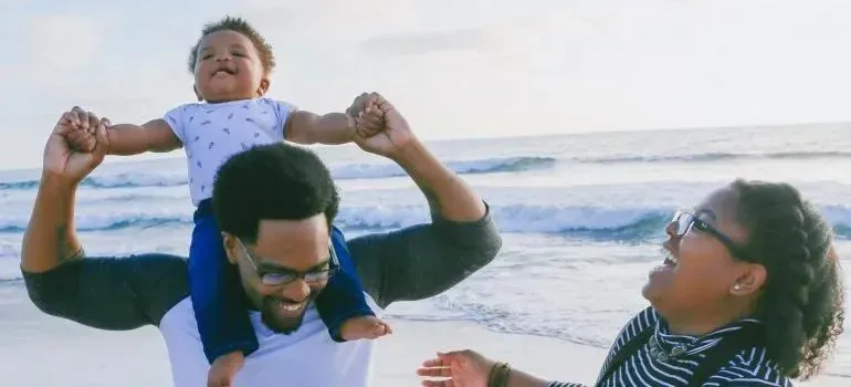 Happy parents playing with baby on the beach