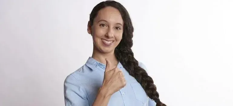 Young woman giving thumbs up against white background