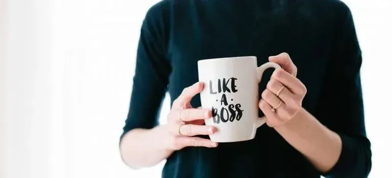 Woman holding mug printed with Like a Boss slogan