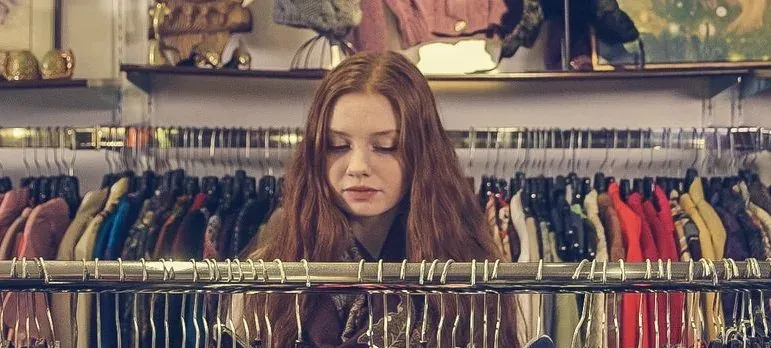 Woman browsing clothing racks in shop