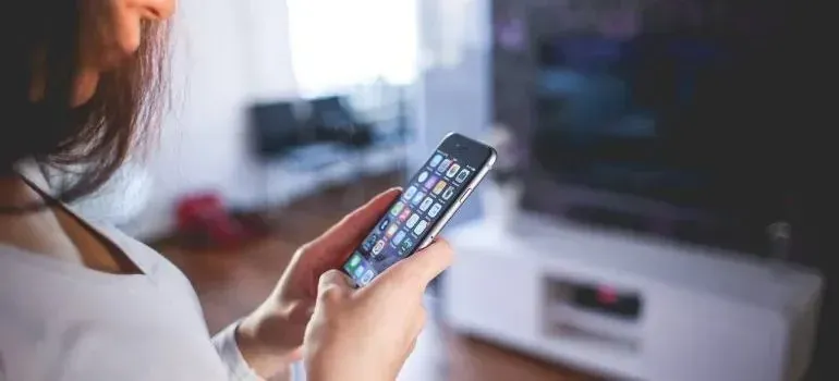Woman browsing apps on smartphone in living room