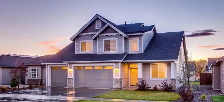 Suburban two-story house with garages at dusk