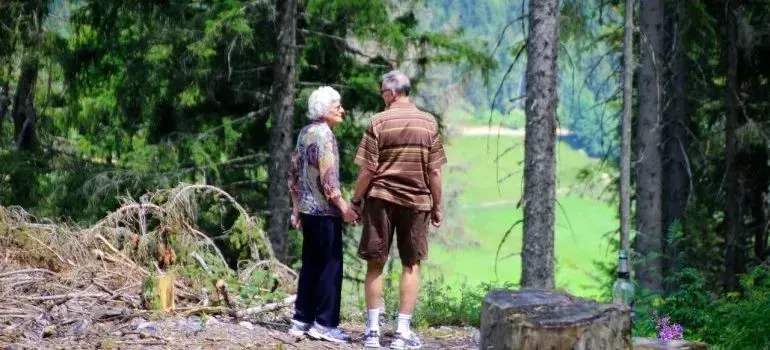 Elderly couple holding hands on forest trail