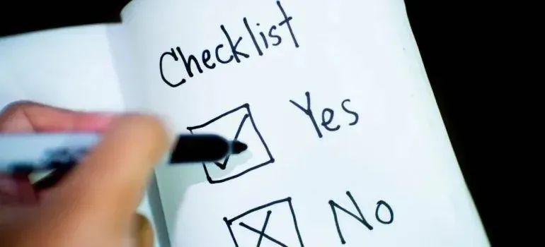 Hand checking yes box on handwritten checklist