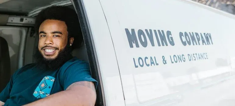 A moving crew carrying boxes outside a New Jersey home