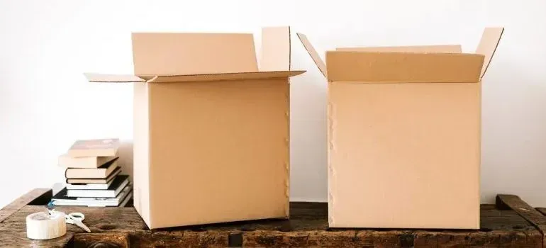 Two open empty cardboard boxes on rustic wooden table