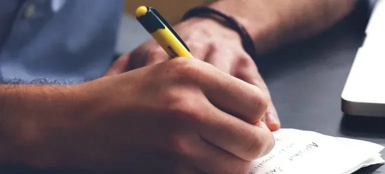 Hand writing on paper with pen