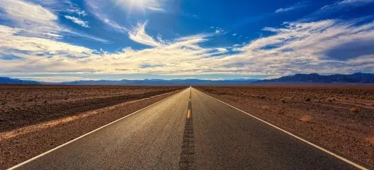 Empty desert highway stretching to horizon under blue sky