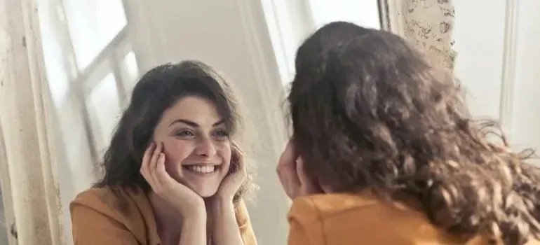Smiling woman looking at her reflection in mirror