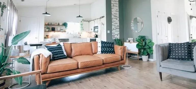 Bright open-plan living room with tan leather sofa