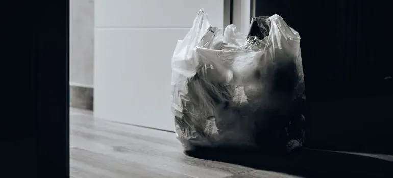 Plastic trash bag by door