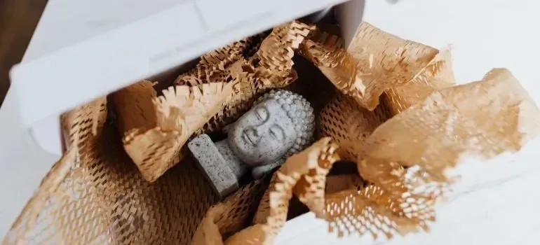 Buddha figurine packed in shredded paper filled box