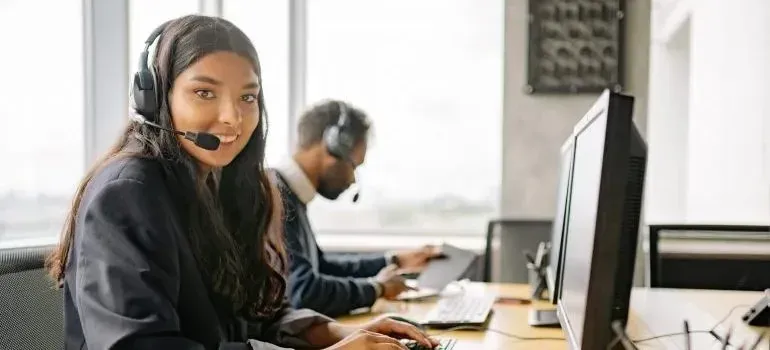 Customer support agents with headsets at office computers