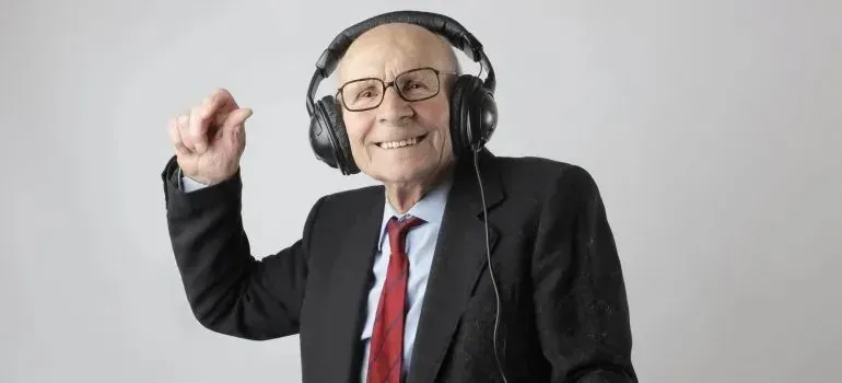 Smiling elderly man in suit wearing headphones