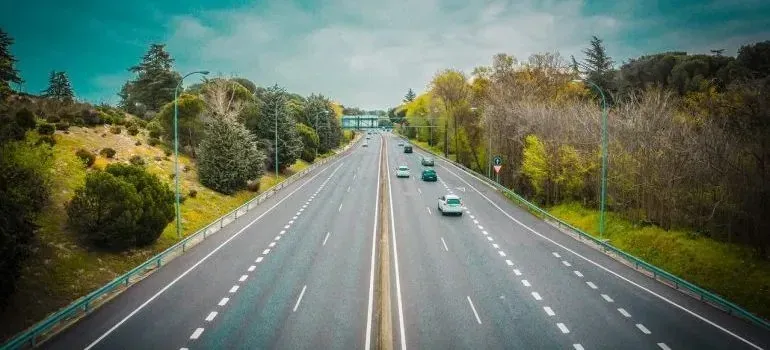 Multi-lane highway with light traffic through greenery