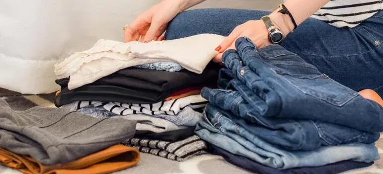 Woman folding stacks of clothes
