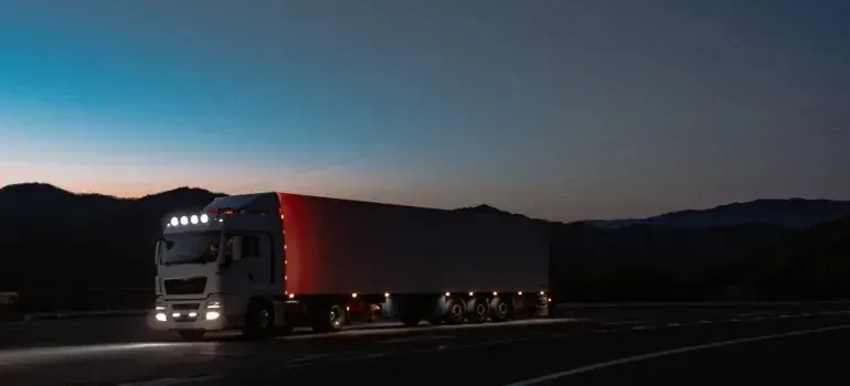 White semi truck on mountain highway at dusk