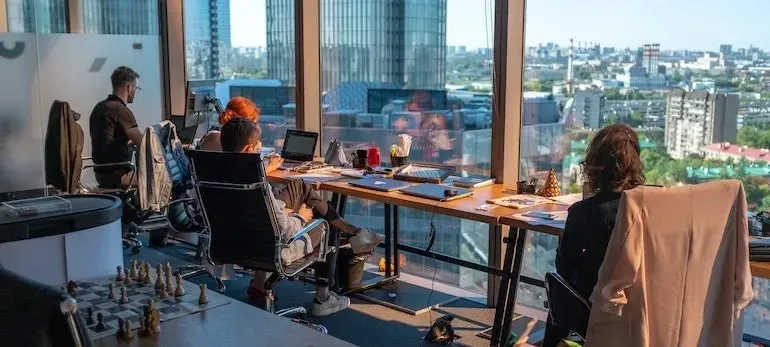 High-rise office with workers at desks, skyline view