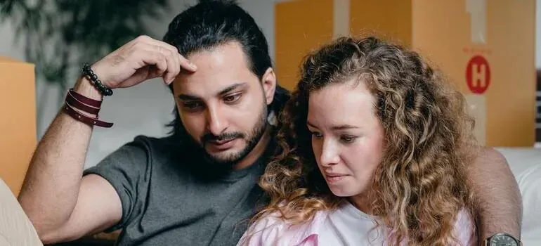 Worried couple among moving boxes