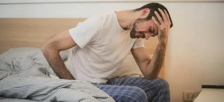 Tired man sitting on bed