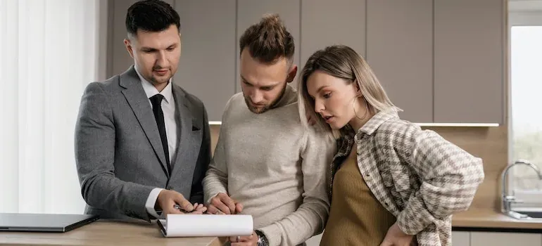 Agent showing couple contract in kitchen