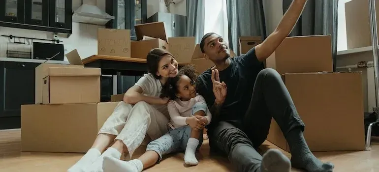 Family taking selfie on floor among moving boxes